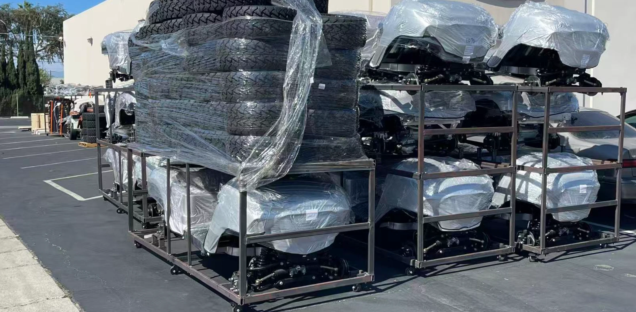 Wrapped golf cart bodies, tires and vehicle frames staged in batches outside the Ontario, California warehouse